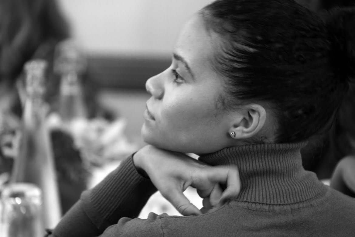 Close-up shot of a person calmly paying attention to a presentation with their chin resting on their hand